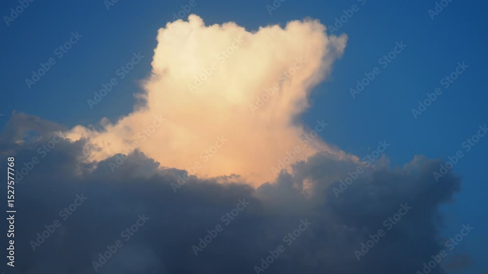 Poster A captivating display of towering cloud formations glows as sunlight grazes their edges, creating a serene and beautiful atmosphere in the evening sky