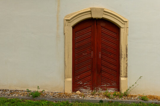 Unique rustic door nestled in a charming wall, inviting curiosity and capturing the essence of timeless architecture
