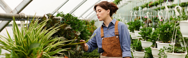 Young woman cultivates lush plants in an inviting greenhouse filled with greenery