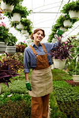 Gardening bliss in a vibrant greenhouse with a passionate young woman at work