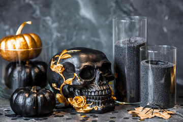 Scary black skull with golden roses, pumpkins and candles for Halloween or Day of the Dead party on...