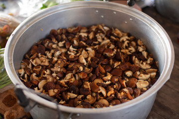 Shiitake mushrooms are cut into pieces and placed on a metal tray.