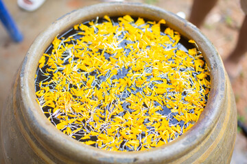 Marigolds are floating in a jar of water.