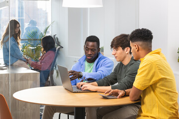 Young professionals collaborating on laptop in modern office
