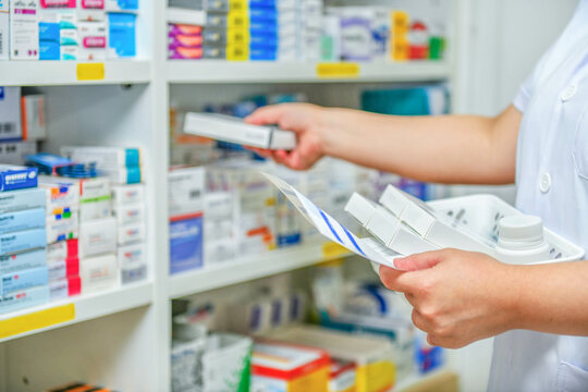 Pharmacist filling prescription in pharmacy drugstore
 - Powered by Adobe