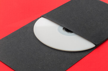 White CD, DVD, Blu Ray, Optical Disc printed side up in black envelope, on red background