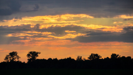 sunset, horizon, trees, dark, colors, orange, clouds, cloudscape, silhouettes, light, golden hour, real photo
