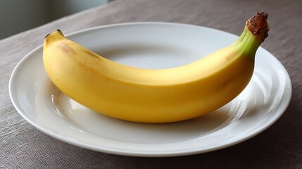 A single ripe banana placed on a white plate