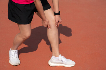 Cropped shot view of Female runner suffering from Iliotibial Band Syndrome (ITB). It cause from...