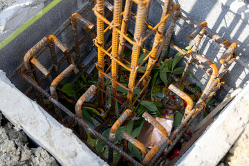 Close-up of a concrete foundation with a steel rebar cage inside, prepared for construction