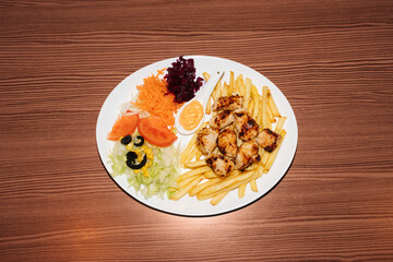 Turkish kebab plate with fries, vegetables and chicken