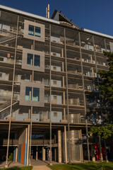 A modern building in Constance, Germany, featuring a prominent grid-like metal facade. The structure is multi-story with large horizontal and vertical elements.