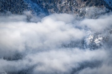 Obraz premium winter mountain landscape with snow, fog and cloud covered areas