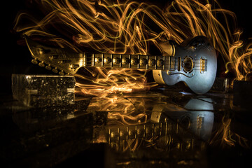 Music Concept: Guitar Miniature on a Dark Background with Vivid Light, Smoke, and Fire Effects. Golden electro guitar under a Dramatic Spotlight.