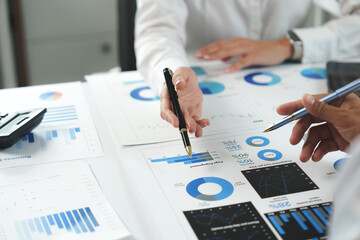 Business people analyzing financial charts and graphs at office desk