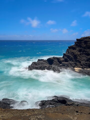 Fototapeta premium Long exposure scenic view of Halona Cove, Oahu, Hawaii, USA against Pacific Ocean and blue sky with clouds