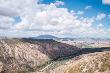 Badlands of gorafe desert showing eroded sandstone formations under cloudy sky
