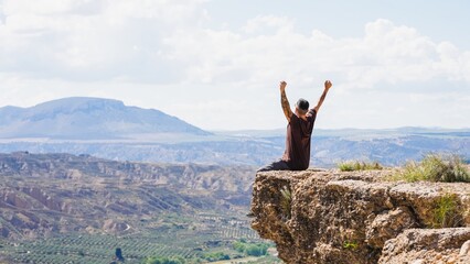Tourist celebrating success on cliff in gorafe, spain