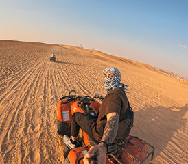 Tourist riding quad bike and taking selfie in desert near giza pyramids