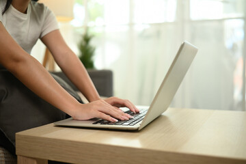 Close-up of a teenage girl hands using a laptop, A cozy home study space, Remote Work and Study Setup Concept