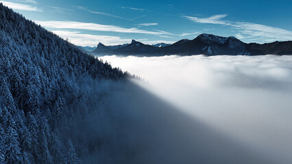 winter mountain landscape with snow, fog and cloud covered trees and skies