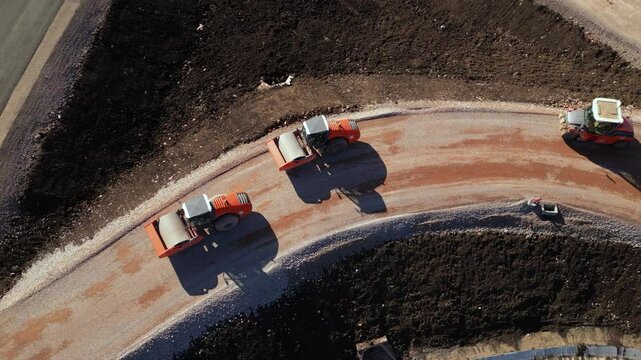 Orange road rollers compacting an access ramp