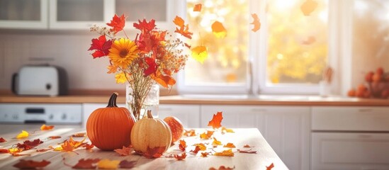 Autumn kitchen interior. Red and yellow leaves and flowers in the vase and pumpkin on light background