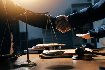 Obraz premium Attractive young lawyer in office Business woman and lawyers discussing contract papers with brass scale on wooden desk in office. Law, legal services, advice, Justice and real estate concept.