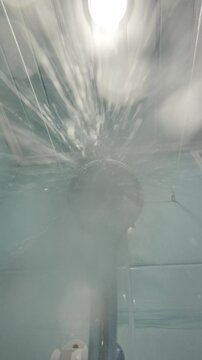 The shower turns on, the water flows to the camera.	
