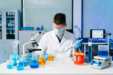 Fototapeta premium Scientist mixing chemical liquids in the chemistry lab. Researcher working in the laboratory