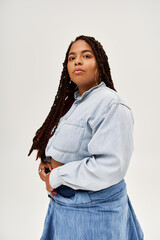 Confident african american woman in denim outfit poses gracefully in studio
