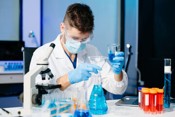 Fototapeta premium Scientist mixing chemical liquids in the chemistry lab. Researcher working in the laboratory