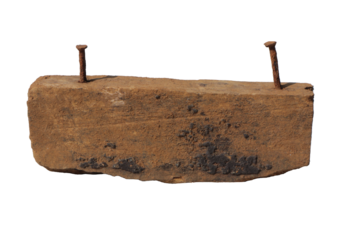 Aged wood block with two rusty nails protruding from the top surface weathered texture
