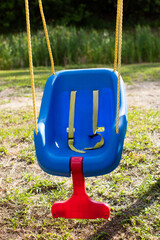 an empty safe blue plastic babies and children's swing on a playground