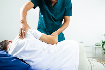 Obraz premium Male physiotherapist applies manual therapy on patient's back during rehab session. Spine care, posture alignment, and muscle relief