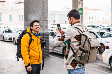 Tourist taking photo of friend near taxi station