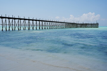 Wooden pier on jambiani beach at Indian Ocean in African Zanzibar island in Tanzania