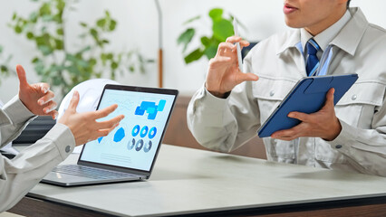 オフィスで打ち合わせする作業員グループ