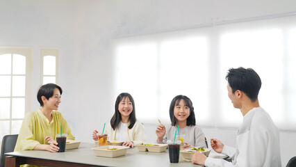 デリバリーフードを食べる女の子の家族