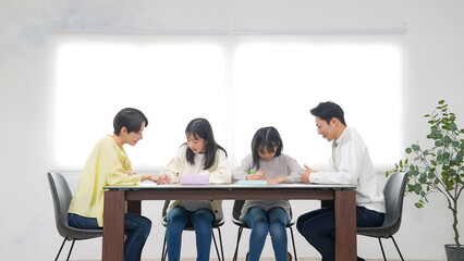 勉強する二人の女の子と指導する男女
