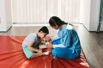 Nurse bandaging child's foot during physiotherapy session