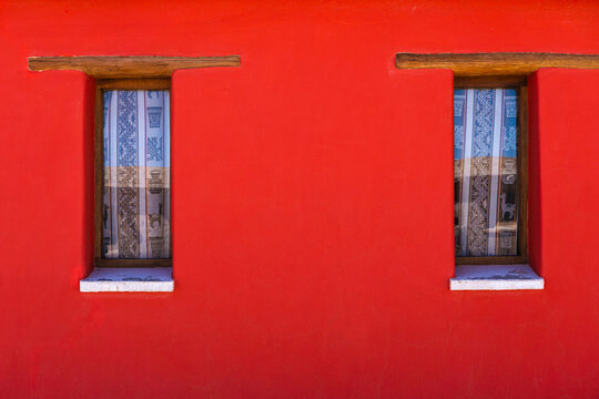 Rustic windows in vibrant red wall in La Puna, Argentina