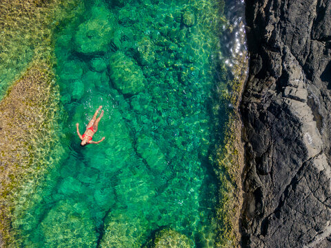 Woman floating in natural pool at Fuerteventura