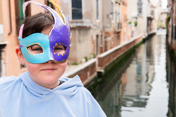 Child with vibrant carnival mask in Venice