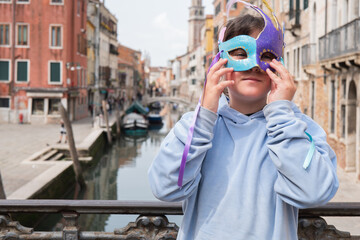 Child in Venice wearing a colorful carnival mask