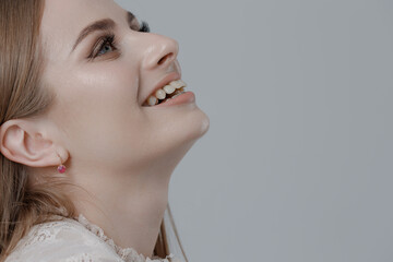 Portrait of a woman smiling softly against a neutral background during a modern photography session in a studio setting