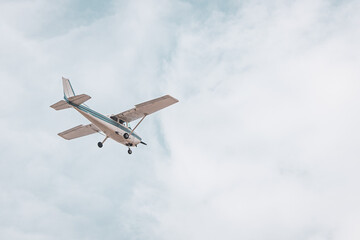 Private Airplane in Flight – Small Aircraft Landing or Taking Off in a Cloudy Blue Sky