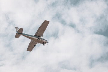 Private Airplane in Flight – Small Aircraft Landing or Taking Off in a Cloudy Blue Sky