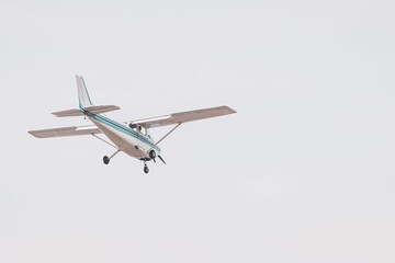 Private Airplane in Flight – Small Aircraft Landing or Taking Off in a Cloudy Blue Sky