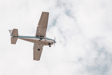 Private Airplane in Flight – Small Aircraft Landing or Taking Off in a Cloudy Blue Sky